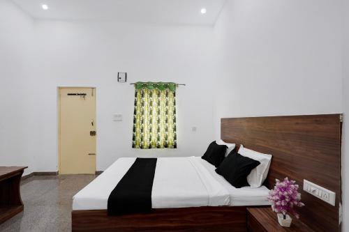 a bedroom with a large bed and a window at Hotel O B.N.R. INN in Bangalore