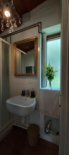 a bathroom with a sink and a mirror and a window at Giardino Antico in Montecarotto