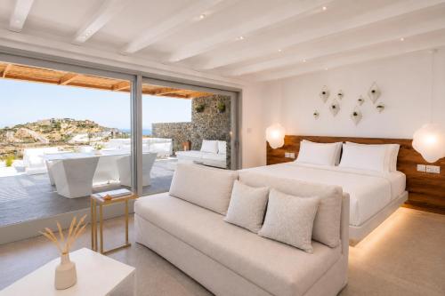 a bedroom with a white bed and a couch at Elements Sifnos in Sifnos