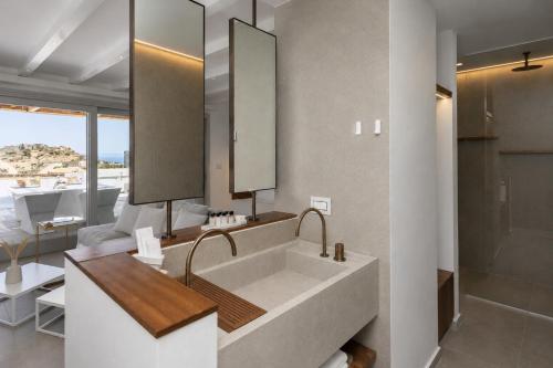 a bathroom with a large sink and a mirror at Elements Sifnos in Sifnos