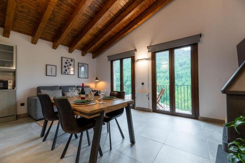 a kitchen and dining room with a wooden table and chairs at Can Pont in Camprodon