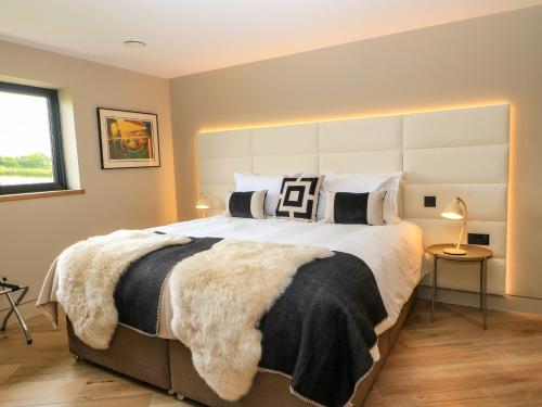 a bedroom with a large bed with black and white pillows at The Cozie Sow in Yeovil