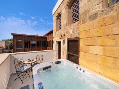 a hot tub on the patio of a building at Jivaeri Luxury Suites in Rhodes Town