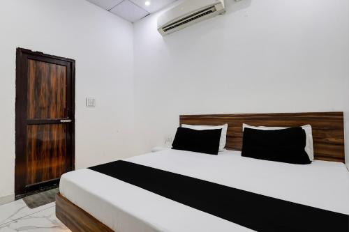 a bedroom with a large white bed with black pillows at Hotel O JIND RESORT in Jīnd