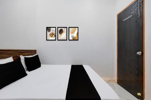 a bedroom with a bed with three pictures on the wall at Hotel O JIND RESORT in Jīnd