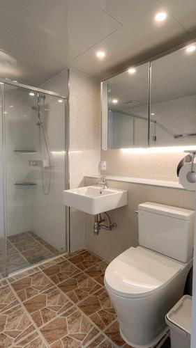 a bathroom with a toilet and a sink and a shower at Plott Archive Jeju in Jeju