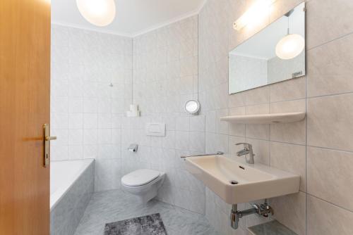 a white bathroom with a sink and a toilet at Bergvilla-Ramsau in Ramsau am Dachstein