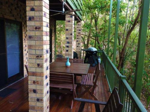 a deck with a wooden table and chairs on a porch at Avalon in Arcadia