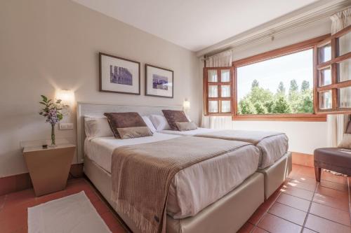 a bedroom with a large bed and a window at Hotel San Antonio el Real in Segovia