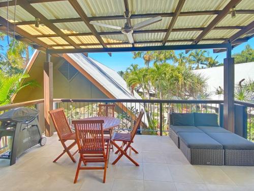 a patio with a couch and chairs and a table at Pure Magnetic Villa 9 in Nelly Bay