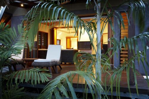 a porch with a white chair and some plants at Pure Magnetic Villa 8 in Nelly Bay
