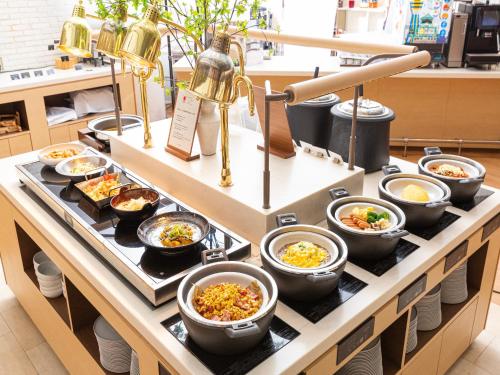 a buffet filled with bowls of food on a table at Hotel Keihan Kyobashi Grande in Osaka