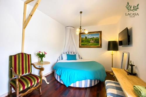a bedroom with a bed and a desk and a chair at Lacasa May in Da Lat