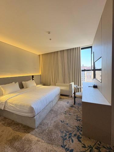a hotel room with a bed and a large window at فندق سدو بوتيك التحلية in Medina