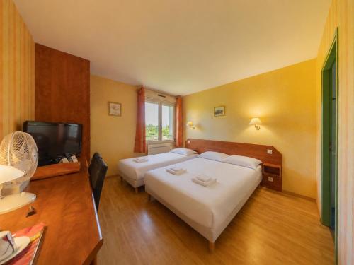 a hotel room with two beds and a flat screen tv at Le Relais du Mess in Vacherauville