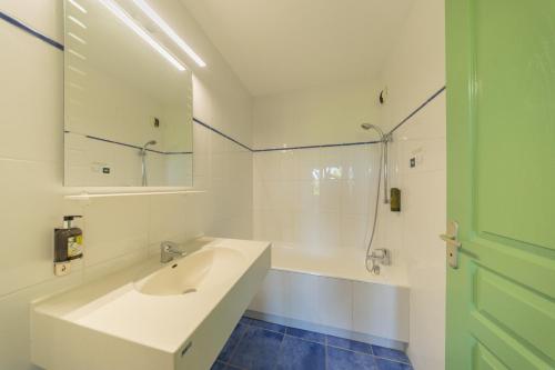 a white bathroom with a sink and a shower at Le Relais du Mess in Vacherauville