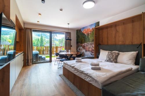 a bedroom with a large bed and a living room at Gora Luxury Apartments in Kranjska Gora