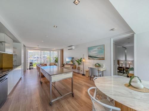 a kitchen and living room with a table and a dining room at Blue on Blue Apartment 1011 in Nelly Bay