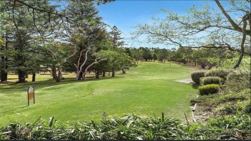 a lush green field with trees and a golf course at The Castle Wentworth Falls in Wentworth Falls