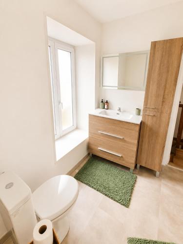 a bathroom with a sink and a toilet and a window at Maison 6 pers - Entre mer & Mont-Saint-Michel in Beauchamps