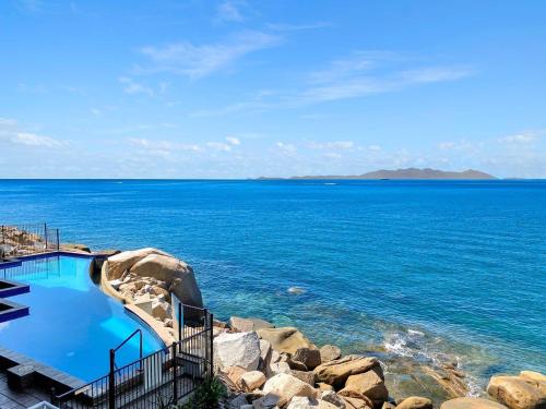 a swimming pool on the shore of a large body of water at 1 Bright Point Apartment 4203 in Nelly Bay