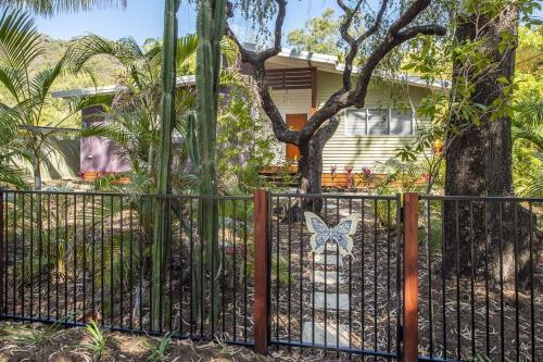 a black fence with a butterfly on it in front of a house at Papillon Bleu in Horseshoe Bay