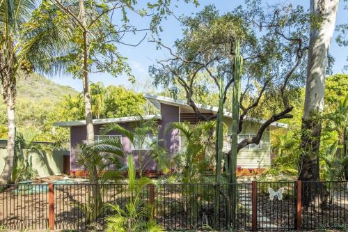 a house with a fence and trees at Papillon Bleu in Horseshoe Bay