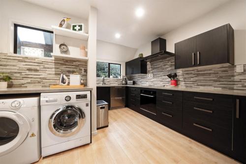 a kitchen with a washer and dryer in it at Sarahs Scenic Stay Mountain Lake Views in Queenstown