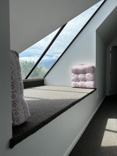 a room with a large window with a chair in it at Sarahs Scenic Stay Mountain Lake Views in Queenstown