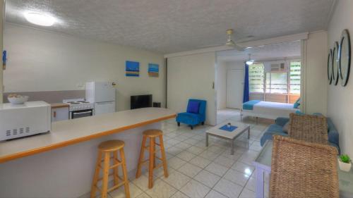 a kitchen and living room with a counter and chairs at Loyang Apartment 1 in Arcadia
