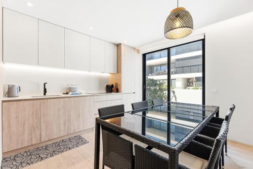 a kitchen and dining room with a glass table and chairs at GuestReady - Beachfront retreat with pools in Apúlia
