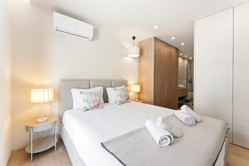 a bedroom with a large white bed with towels on it at GuestReady - Beachfront retreat with pools in Apúlia
