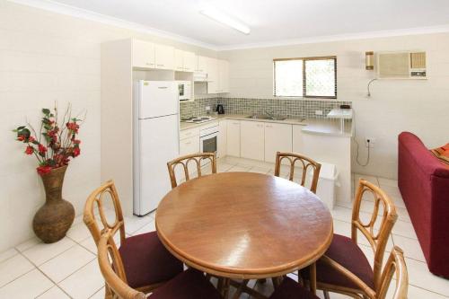 a kitchen and dining room with a wooden table and chairs at Alma Bay Holiday Unit 4 in Arcadia