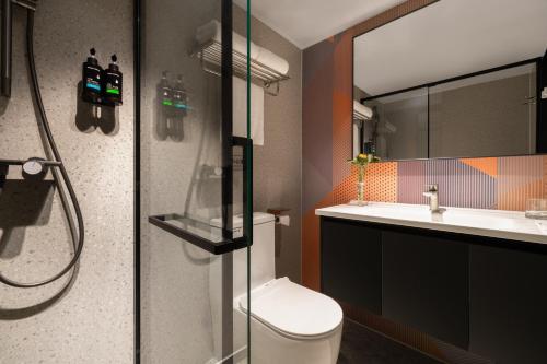 a bathroom with a shower and a toilet and a sink at Guang Dong Hotel in Guangzhou