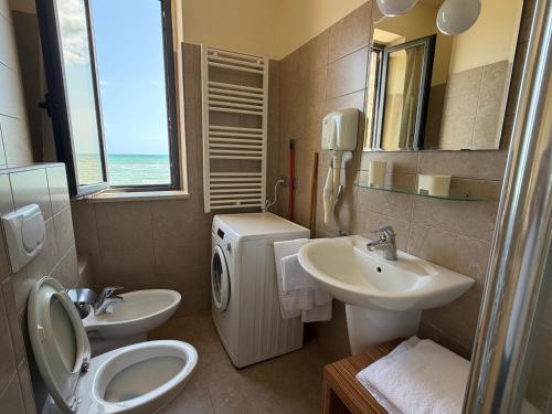 a bathroom with a sink and a toilet and a mirror at Residenza La Signora vista mare con ascensore in Marotta