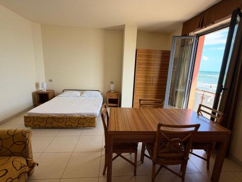a bedroom with a table and a bed and a table and chairs at Residenza La Signora vista mare con ascensore in Marotta