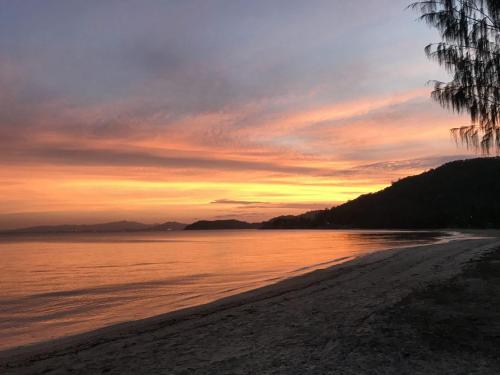 a sunset on a beach with the ocean at 1 Bright Point Apartment 2303 in Nelly Bay