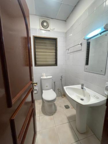 ein Badezimmer mit Toilette und Waschbecken in der Unterkunft Private flats in Salalah