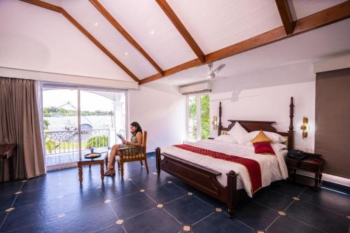 a woman sitting in a chair in a bedroom at Le Mont Lagoon Home Stay in Cochin