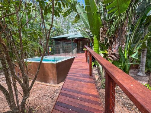 a wooden walkway leading to a house with a swimming pool at Marramaninjie in Arcadia