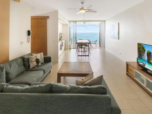 a living room with a couch and a tv and a table at 1 Bright Point Apartment 4502 in Nelly Bay