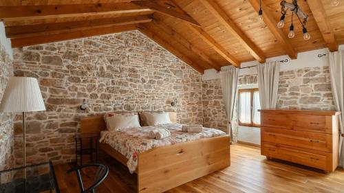 a bedroom with a bed in a stone wall at Old House Grota by Villas Guide in Umag