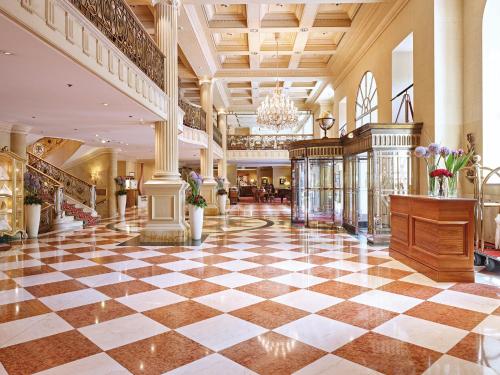 a lobby with a checkered floor and a chandelier at Grand Hotel Wien in Vienna