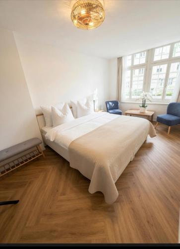 ein Schlafzimmer mit einem großen weißen Bett und einem Kronleuchter in der Unterkunft Emelie in Thun
