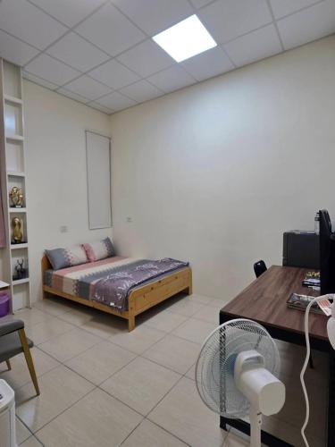 a room with a bed and a desk with a computer at 南田旅宿親子商務 in Fengyuan