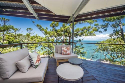 a balcony with a couch and a table at Headland House in Picnic Bay