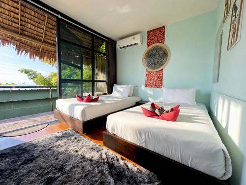 a bedroom with two beds and a large window at Phi Phi Sea Sky Resort in Phi Phi Islands