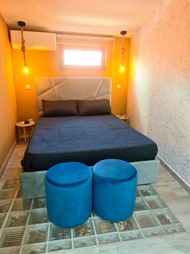a bedroom with a bed and two blue stools at Maison M in Portimão