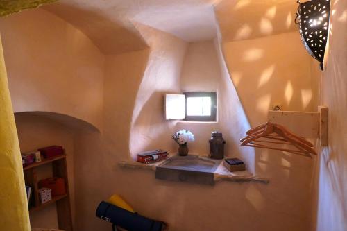 a room with a wall with a shelf and a refrigerator at Chambre d'Hôtes La Chadeleufade in Chadeleuf