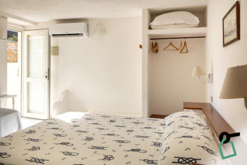 a white bedroom with a bed with a blanket on it at Hotiday Ponza Scogliera in Ponza